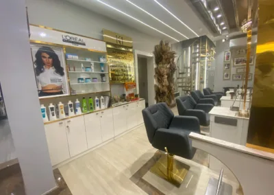 The stylish interior of KM Orgatonics salon in Gorakhpur, displaying L'Oréal hair products, comfortable styling chairs, and a decorative floral arrangement.